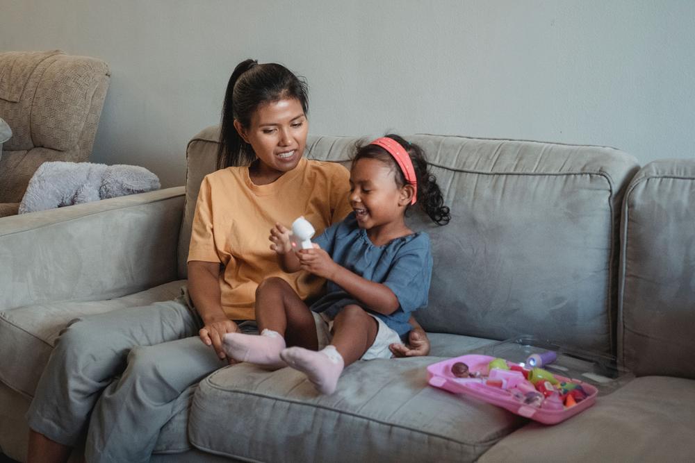 A mother and her young daughter playing together at home