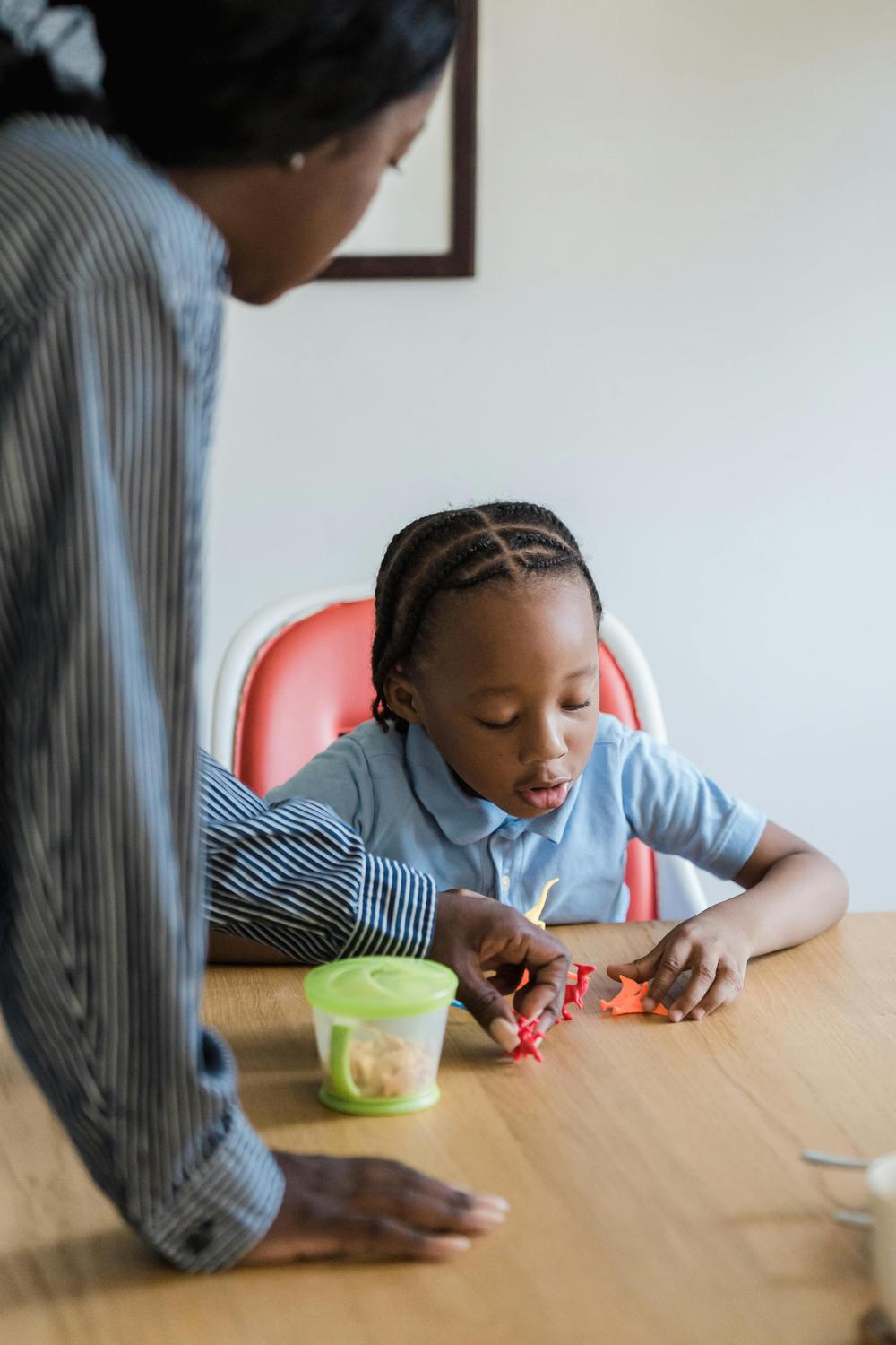 A parent supporting a child during a tabletop learning activity